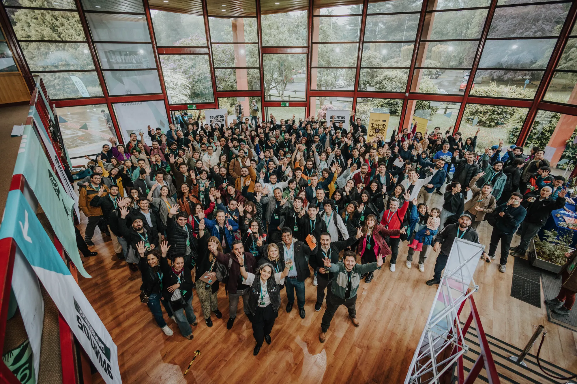 Auditorio lleno de asistentes de 9punto5 saludando a la cámara