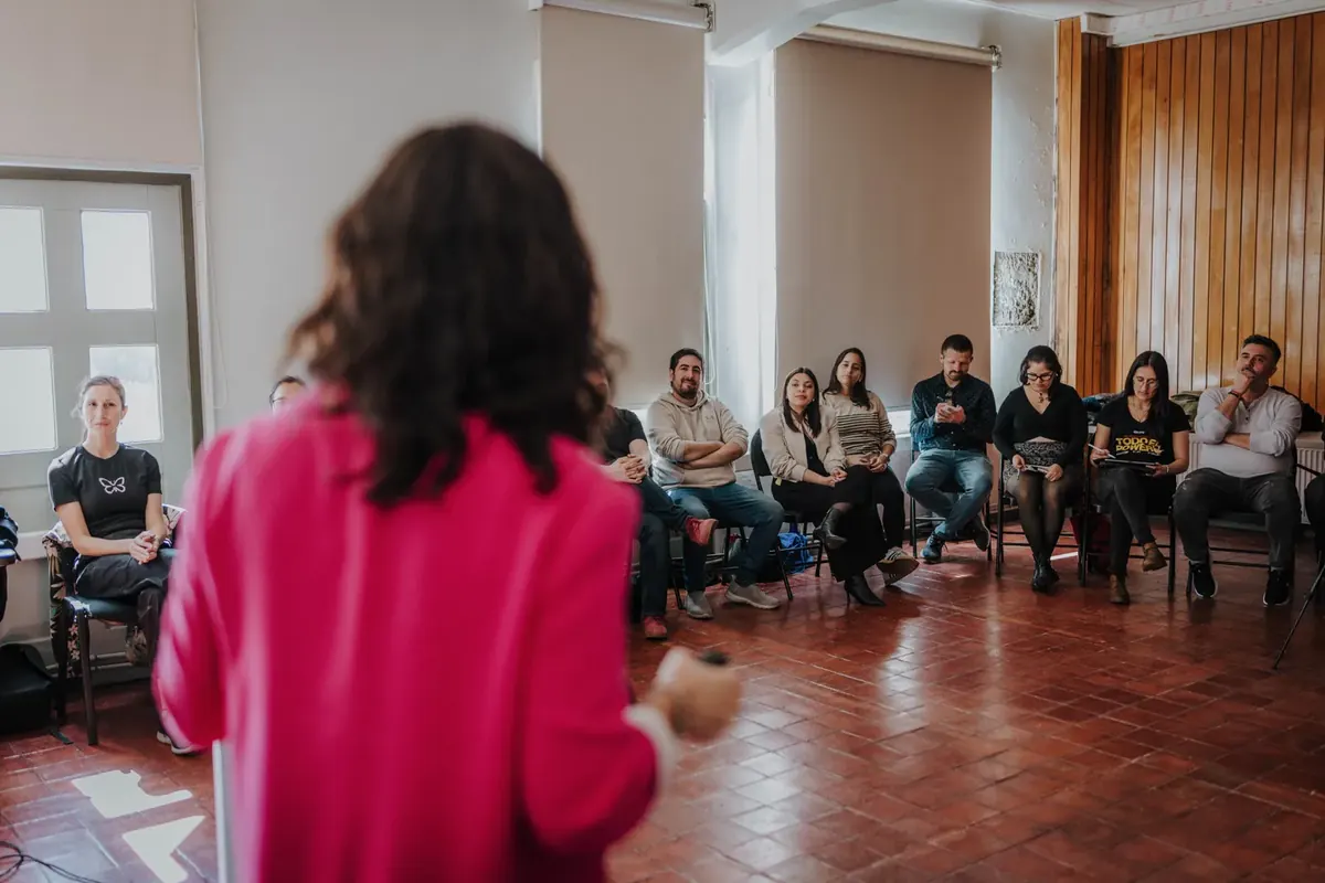 Taller práctico en una sala con asistentes en círculo