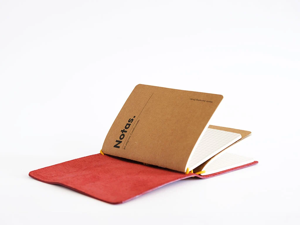 Journal de cuero abierto con cubierta roja y recambio cuadriculado